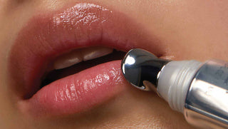 Model lips using Lip Volumizer applicator to apply product